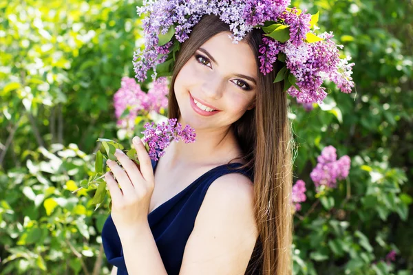 Vacker flicka med en lila blommor — Stockfoto