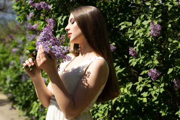 Beautiful girl with a lilac flowers — Stock Photo, Image
