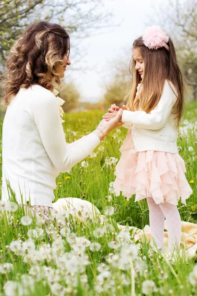 Мать и дочь в поле с одуванчиками — стоковое фото