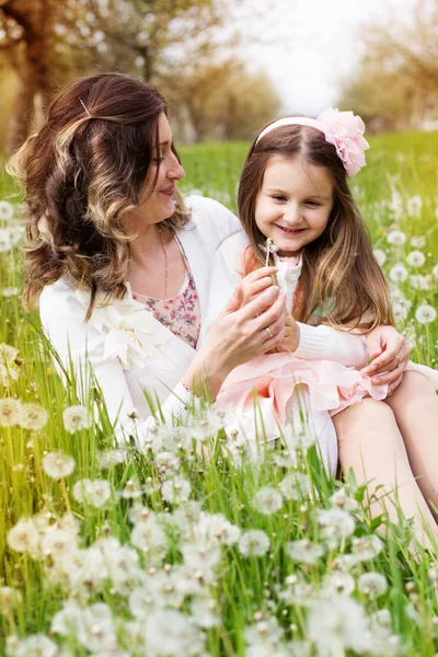 Мать и дочь в поле с одуванчиками — стоковое фото