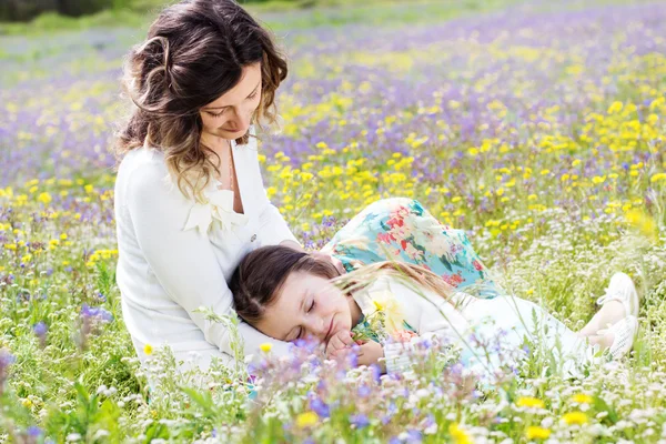 Mãe e filha no campo com flores coloridas — Fotografia de Stock