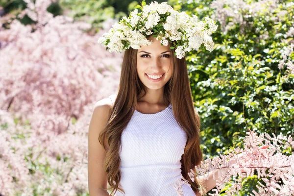Menina bonita na natureza em grinalda de flores — Fotografia de Stock