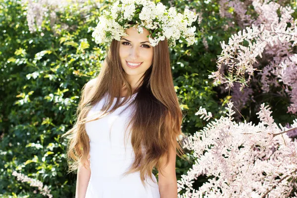 Vacker flicka på naturen i krans av blommor — Stockfoto