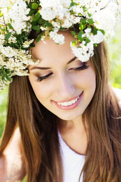 Schönes Mädchen in der Natur im Blumenkranz — Stockfoto