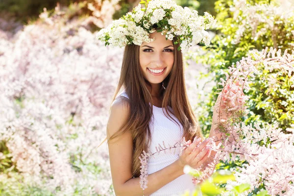 Vacker flicka på naturen i krans av blommor — Stockfoto