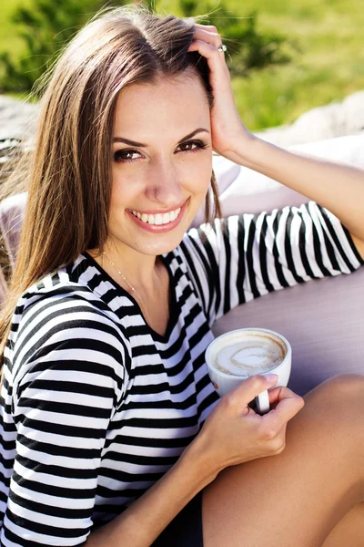 Jonge vrouw drinken koffie in een café in de buitenlucht — Stockfoto