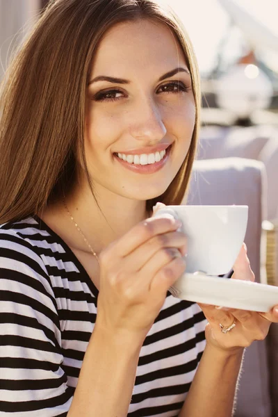 Jonge vrouw drinken koffie in een café in de buitenlucht — Stockfoto