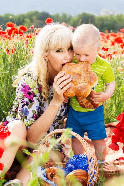 Happy mother and son on the poppies field — Stock Photo, Image