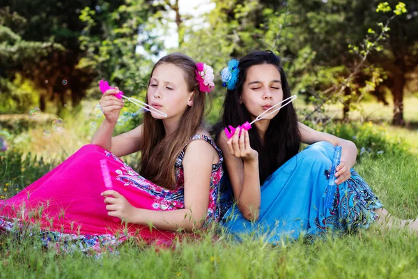 Πορτρέτο του δύο κορίτσια να παίζουν με τον ανεμιστήρα φούσκα — Φωτογραφία Αρχείου