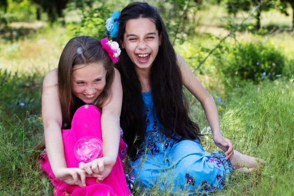 Retrato de duas meninas brincando com o ventilador de bolhas — Fotografia de Stock