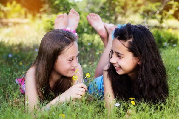 Two sisters laying down in the park — Stock Photo, Image