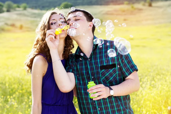 Joven pareja jugar juntos con burbuja ventilador — Foto de Stock