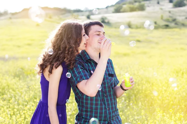 Joven pareja jugar juntos con burbuja ventilador — Foto de Stock