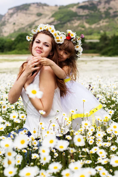 Mother with her child playing in camomile field — Stock Photo, Image