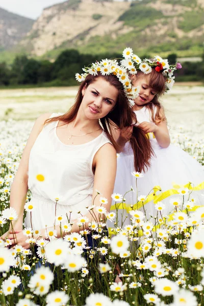 Mother with her child playing in camomile field — Stock Photo, Image