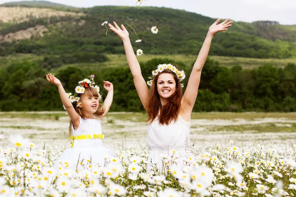 Mother with her child playing in camomile field — Stock Photo, Image