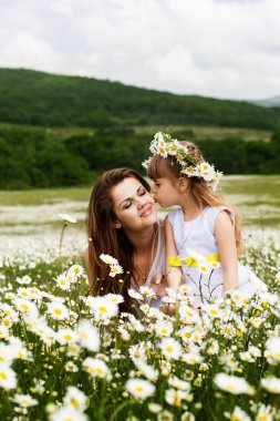 Papatya alanda oynayan çocuk ile anne