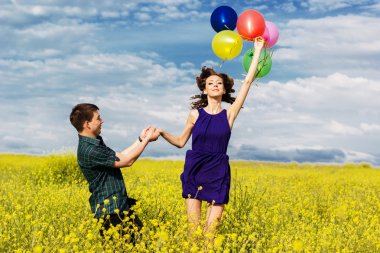 Mutlu çift sarı alan üzerindeki balonlar ile