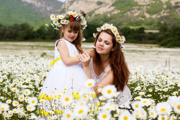 Mãe com seu filho brincando no campo de camomila — Fotografia de Stock