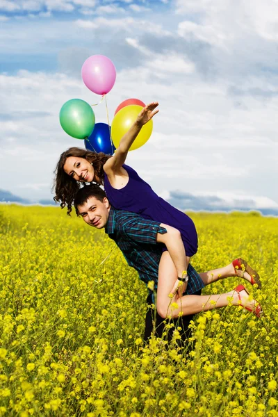 黄色のフィールドに風船で幸せなカップル — ストック写真