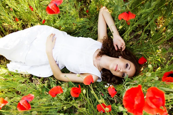 Mooi meisje op het gebied van papavers — Stockfoto