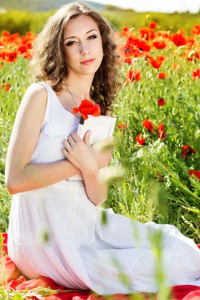 Jovem menina bonita no campo das papoilas — Fotografia de Stock