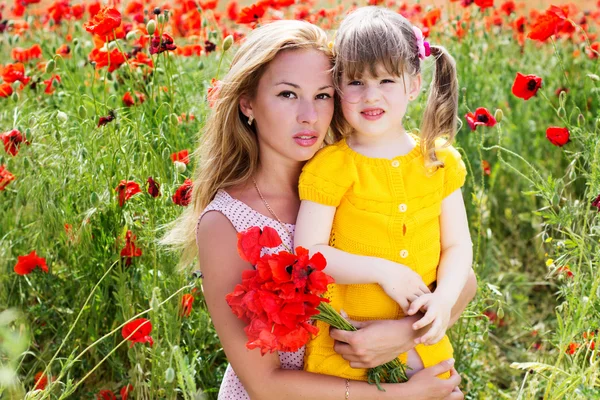 Mother playing with her child in poppy field — Stock Photo, Image