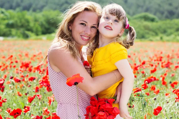 Mother playing with her child in poppy field — Stock Photo, Image