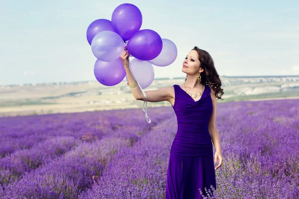 Bedårande flicka med lila ballonger. — Stockfoto