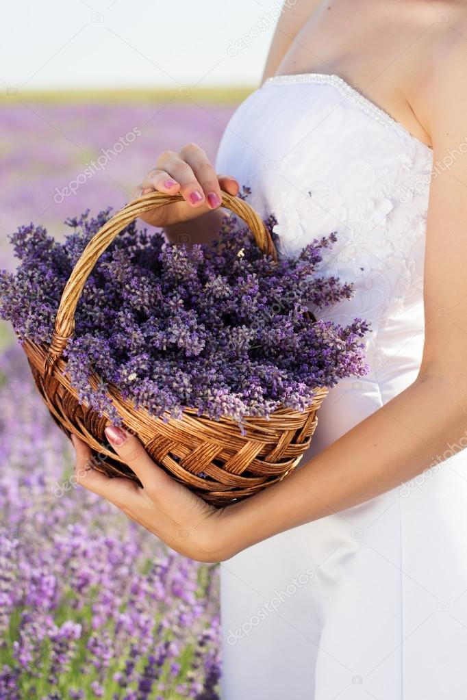 Bride holding basket with lavender flowers