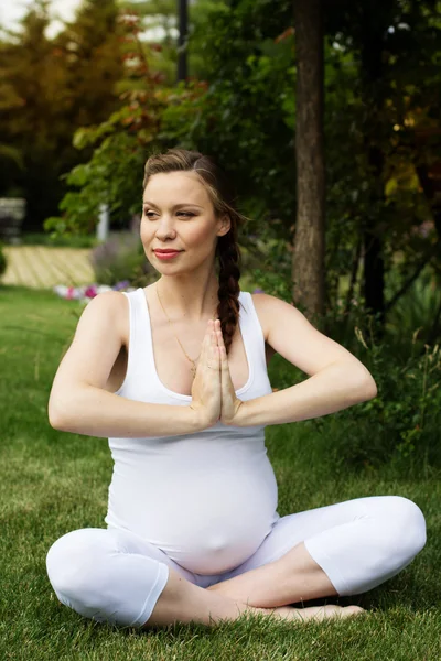 Красива вагітна жінка розслабляється в парку — стокове фото