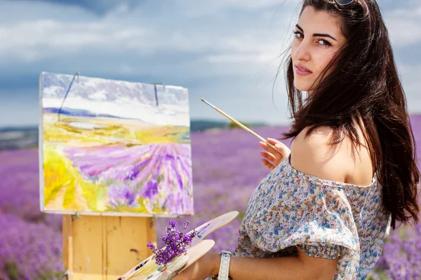 Молодий художник малює в лавандовому полі — стокове фото
