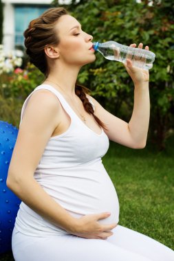 Güzel hamile kadın parkta dinleniyor.