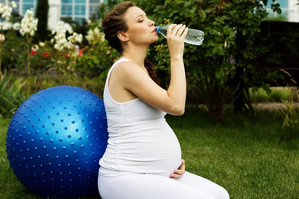 Hermosa mujer embarazada relajándose en el parque Imagen de archivo
