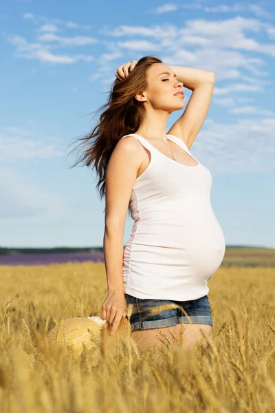 Portret szczęśliwy w ciąży kobieta w polu pszenicy. — Zdjęcie stockowe