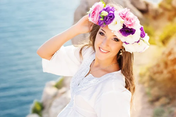 Schöne junge Frau mit Blumenkranz — Stockfoto