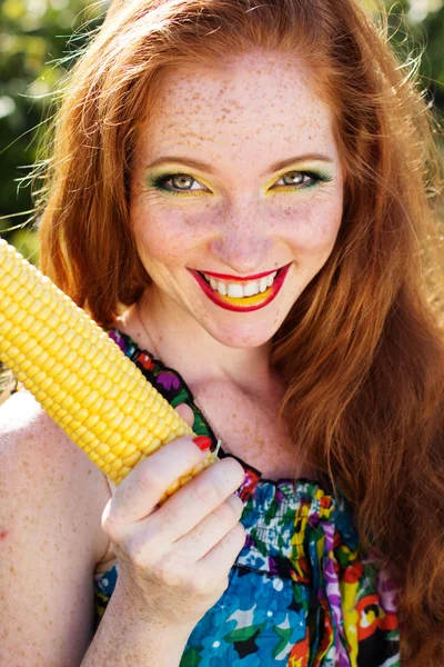 Smiling girl with freckles holding corn cob — Stock Photo, Image
