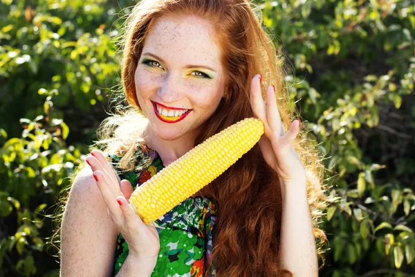 Souriante fille avec des taches de rousseur tenant épi de maïs — Photo