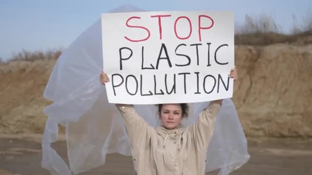 Fiatal nő önkéntes aktivista visel polietilén gazdaság egy környezeti plakát Stop Plastic Pollution demonstrálja elleni védelem környezet, szennyezés jellege