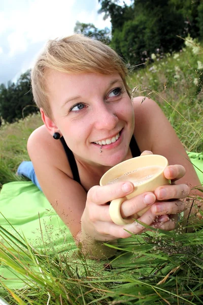 Girls is drinking from a cup on a meadow — Stock Photo, Image