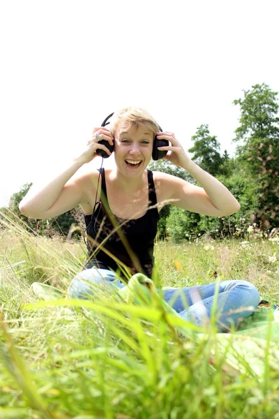 Girl on meadow with headphones — Stock Photo, Image