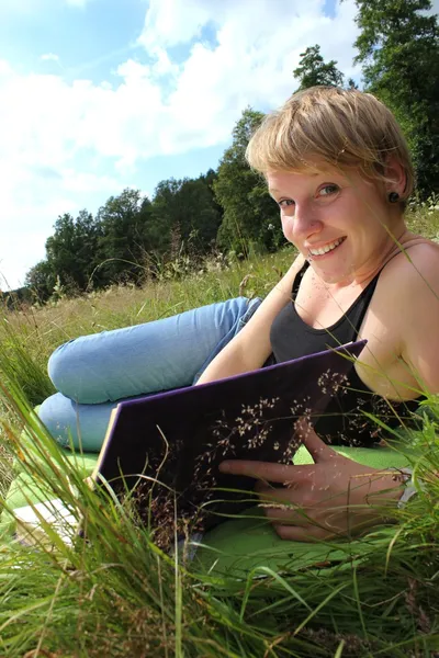 Girl is reading a book on a summer meadow — Stock Photo, Image