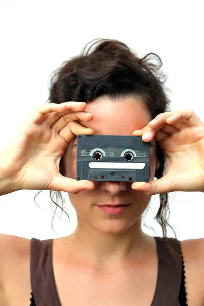 Young woman holding a plain cassette — Stock Photo, Image