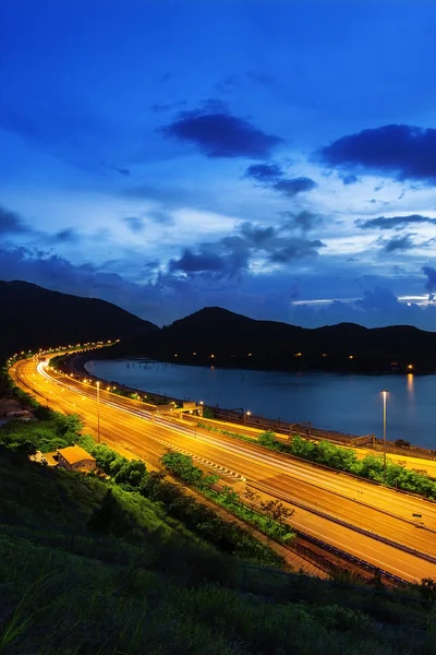 Highway traffic sunset av vatten bay — Stockfoto