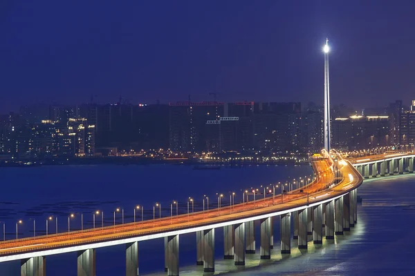 Autobahn in der Nacht mit beleuchteten Autos in der modernen Stadt. — Stockfoto