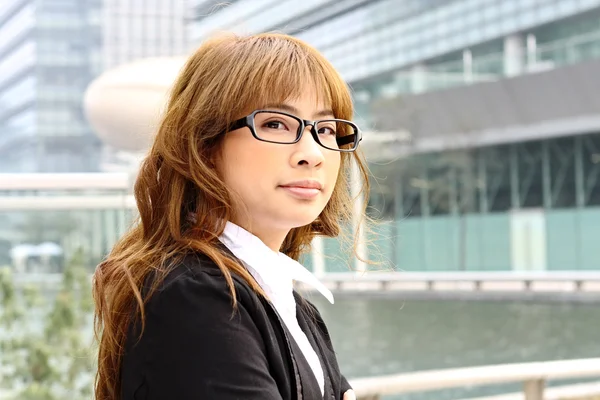 Jonge zakenvrouw en een office-achtergrond — Stockfoto