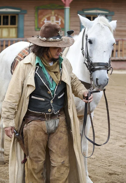 Cowboy de pé ao lado de seu cavalo — Fotografia de Stock