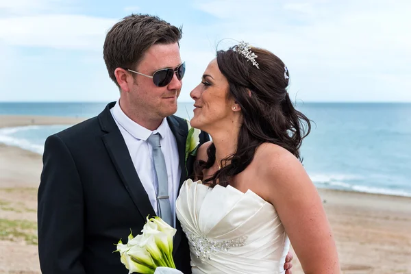 Ženich a nevěsta v den jejich svatby na pláži — Stock fotografie