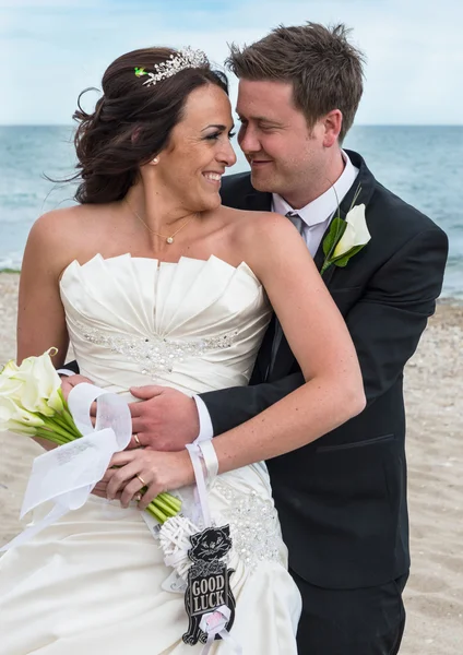 Жених и невеста в день свадьбы на пляже — стоковое фото