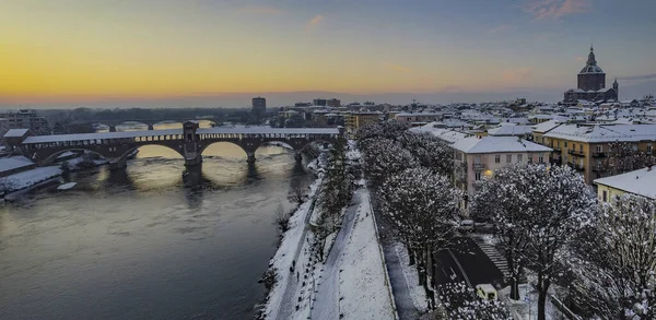 イタリアのパヴィアの冬の空の景色日没 ドームと雪とティチーノ川の古い橋 — ストック写真